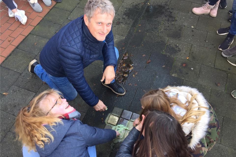 Schulleiter Axel Heinz und Schüler der beiden weiterführenden Schulen haben die Steine gereinigt.