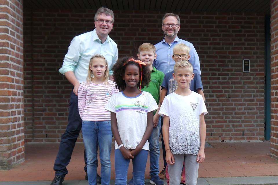 Schulleiter Thomas Schlüter (links) und Mike Marcinowski (Schulpflegschaftsvorsitzender) sowie Vertretrer des Schülerparlaments freuen sich über das Votum.