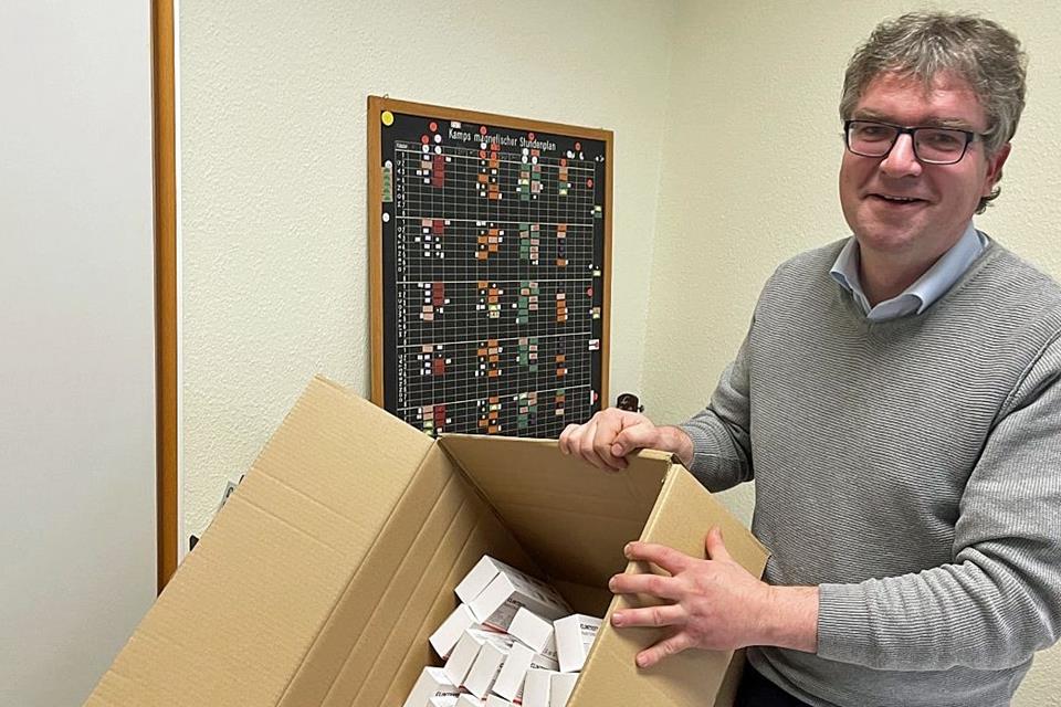 Schulleiter Thomas Schlüter zeigt einen Karton mit Schnelltests.