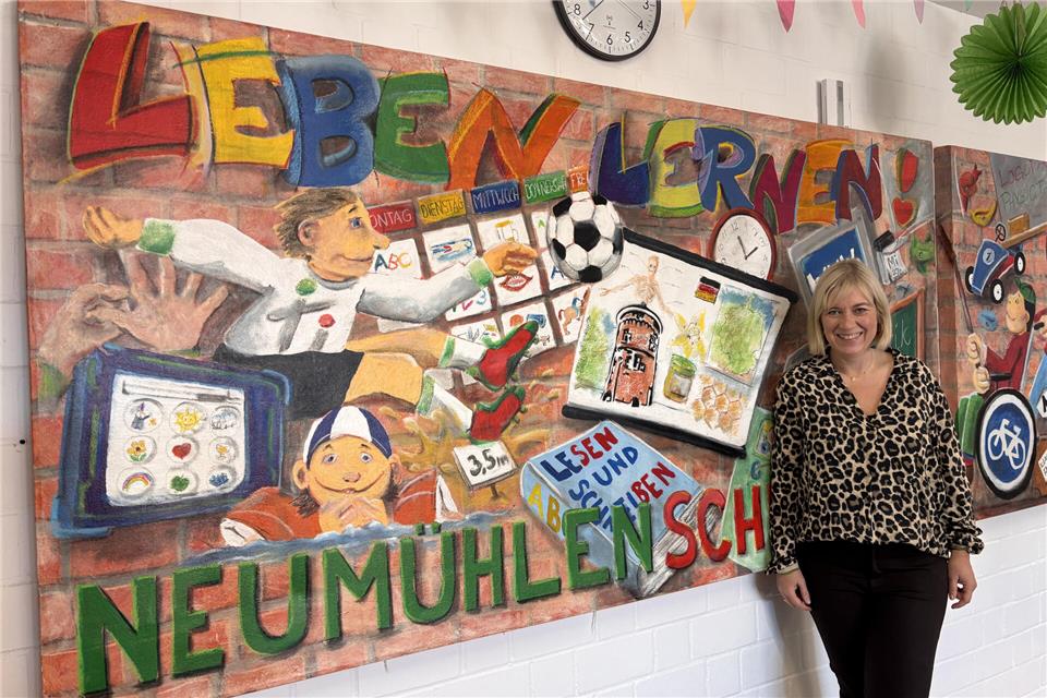 Schulleiterin Silke Nürnberg vor den Wandbildern im Foyer. Sie wurden von der schuleigenen Firma „NeumühlenArt“ erstellt.