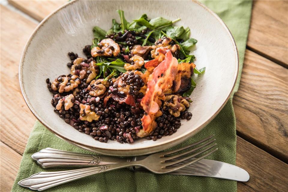 Schwarzen Beluga-Linsen eignen sich perfekt für einen Salat mit Walnüssen, Speck, Petersilie, roten Zwiebeln und Rucola. picture alliance / dpa-tmn