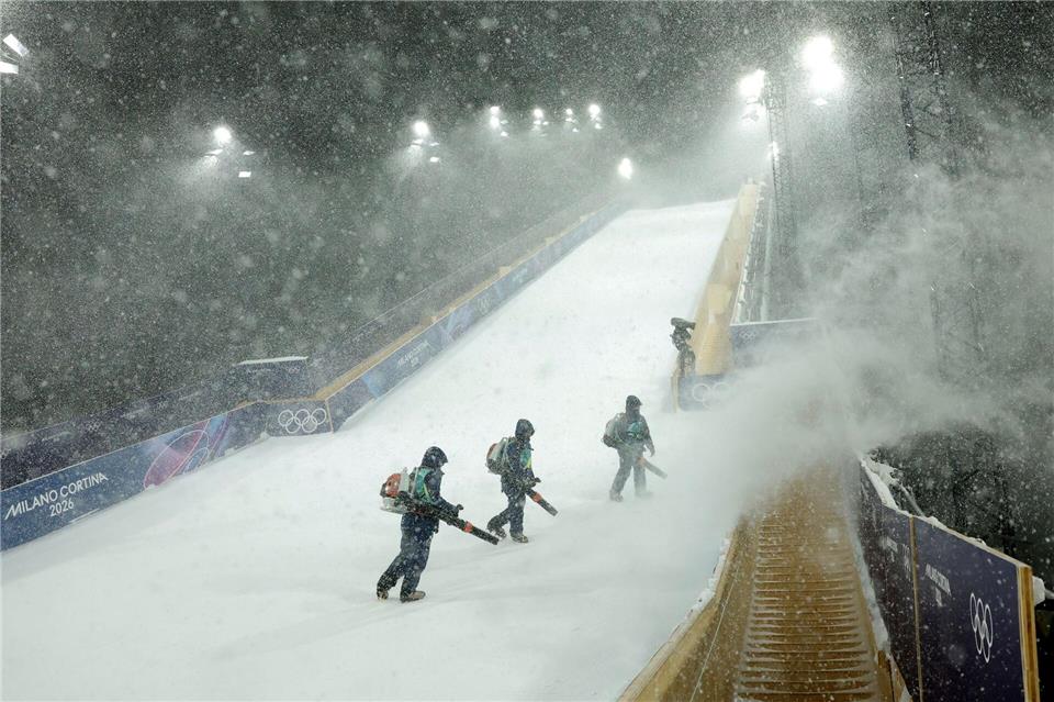 Schwerstarbeit: Die Helfer versuchen die Schanze wettkampftauglich zu machen.Oliver Weiken/dpa