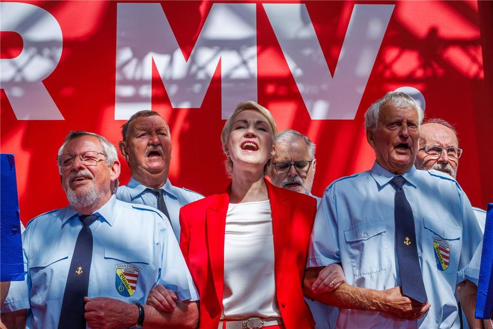 Schwesig schunkelt mit dem Shantychor Wismar beim Parteitag in der Hansestadt.Jens Büttner/dpa