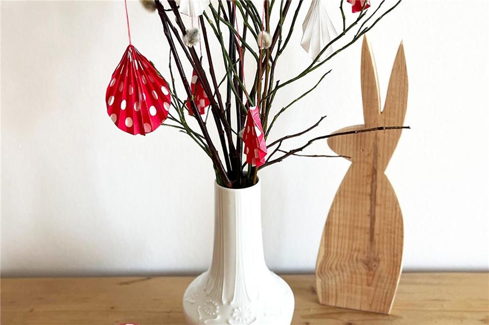 Selbstgemachter Osterschmuck: Aus buntem, gefaltetem Papier werden Anhänger für den Osterstrauß.DIY Academy/dpa-tmn