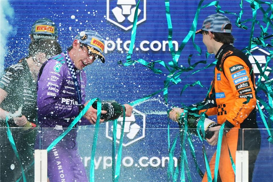 Sieger Mercedes-Pilot Kimi Antonelli (l) aus Italien feiert mit dem drittplatzierten McLaren-Fahrer Oscar Piastri aus Australien auf dem Podium nach dem Großen Preis von Miami.Lynne Sladky/Pool AP/dpa
