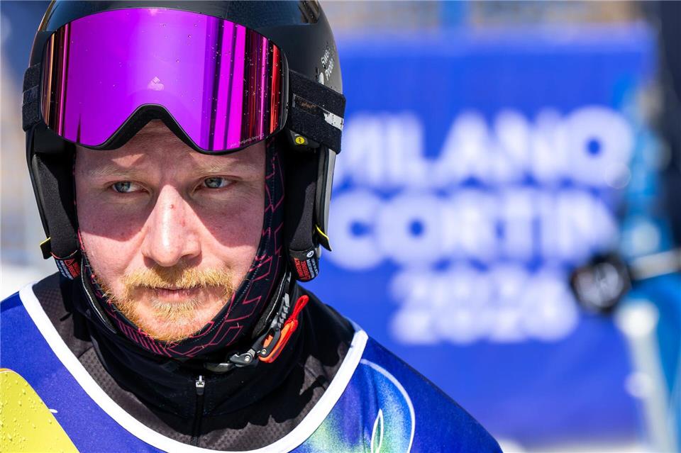 Snowboarder Christian Schmiedt trägt bei der Abschlussfeier die deutsche Fahne. (Archivbild)Philipp von Ditfurth/dpa