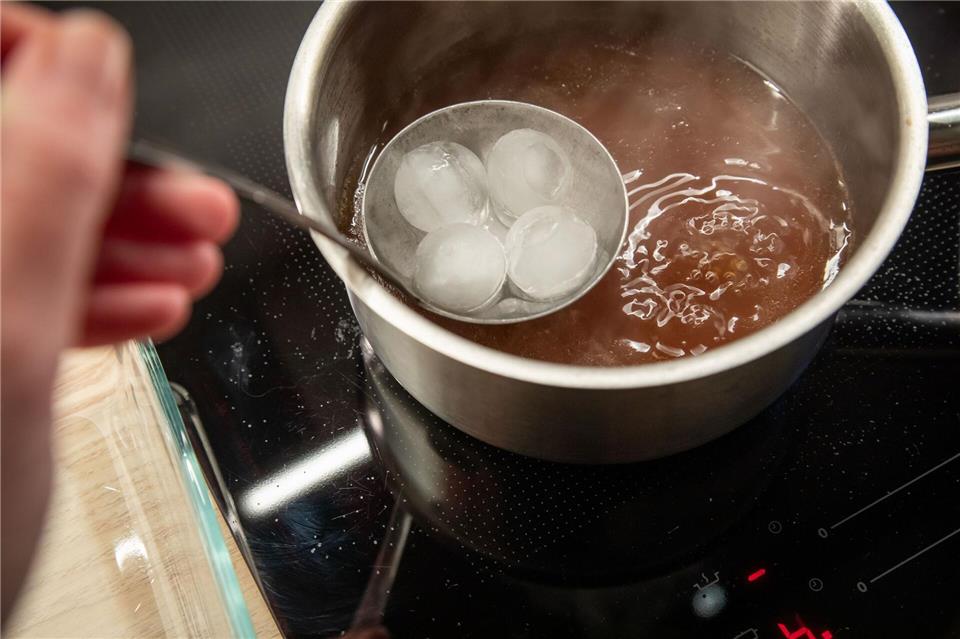 So geht’s: Eiswürfel in einem Schöpflöffel geben und an der Oberfläche der Brühe entlangführen.Christin Klose/dpa-tmn