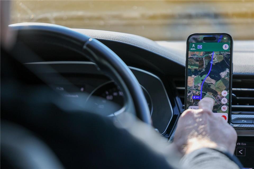 So ist es derzeit erlaubt: Das Handy steckt in der Halterung und wird nur kurz vom Fahrer beachtet. (Symbolbild)Jan Woitas/dpa