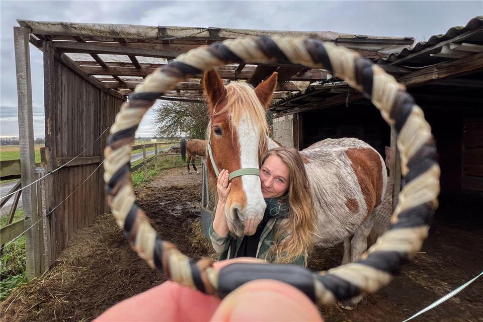 Sophie Dongowski zeigt neben ihrem Pferd Valentino ein aus Pferdehaar und Menschenhaar gefertigtes Armband. Julian Stratenschulte/dpa