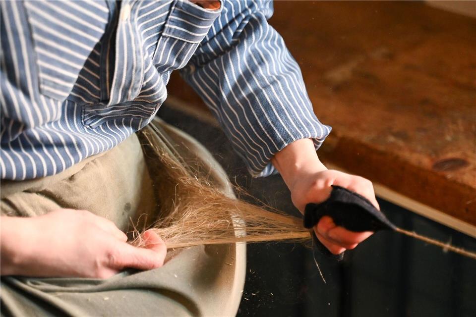 Sophie Muffler spinnt  Flachs für Karbatschen zu Garn. Dabei lässt sie die Fasern durch feuchtes Tuch laufen.Katharina Kausche/dpa