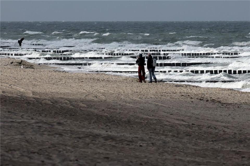 Bilder des Tages Spaziergänger sind am Ostseestrand bei Graal-Müritz unterwegs, wobei nur ab und zu etwas Sonne durch die grauen Wolken am Himmel fällt.Bernd Wüstneck/dpa