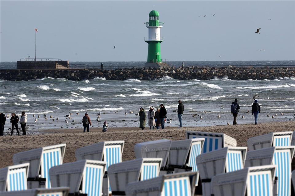 Sturm stoppt Fährverkehr und stört Landeserntedankfest Spaziergänger zieht es trotz des stürmischen Wetters an die Ostsee.Bernd Wüstneck/dpa