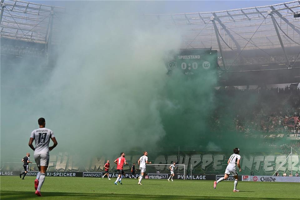Spielfeld im Nebel: Fans von Hannover 96 zünden beim Heimspiel gegen den VfL Wolfsburg Pyrotechnik.Swen Pförtner/dpa