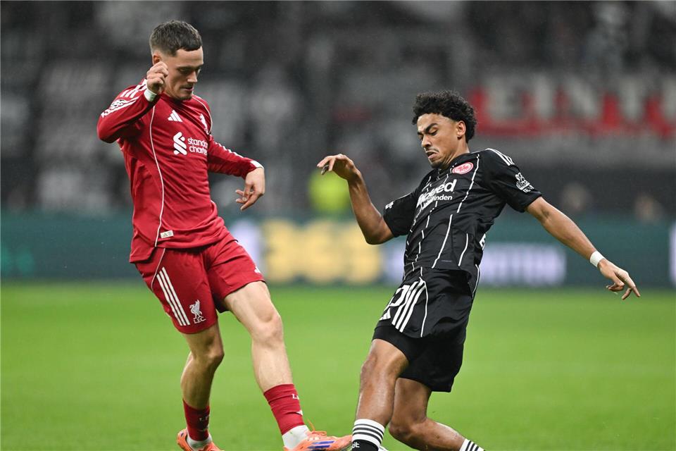 Spielte sich selbst aus und Eintracht Frankfurt um Nathaniel Brown (r) noch tiefer in die Krise: Liverpools Florian Wirtz (l).Arne Dedert/dpa