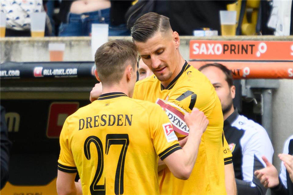 Stefan Kutschke (Dynamo Dresden, r) bekommt bei seiner letzten Einwechslung von Niklas Hauptmann (Dynamo Dresden) die Kapitänsbinde angelegt.Robert Michael/dpa