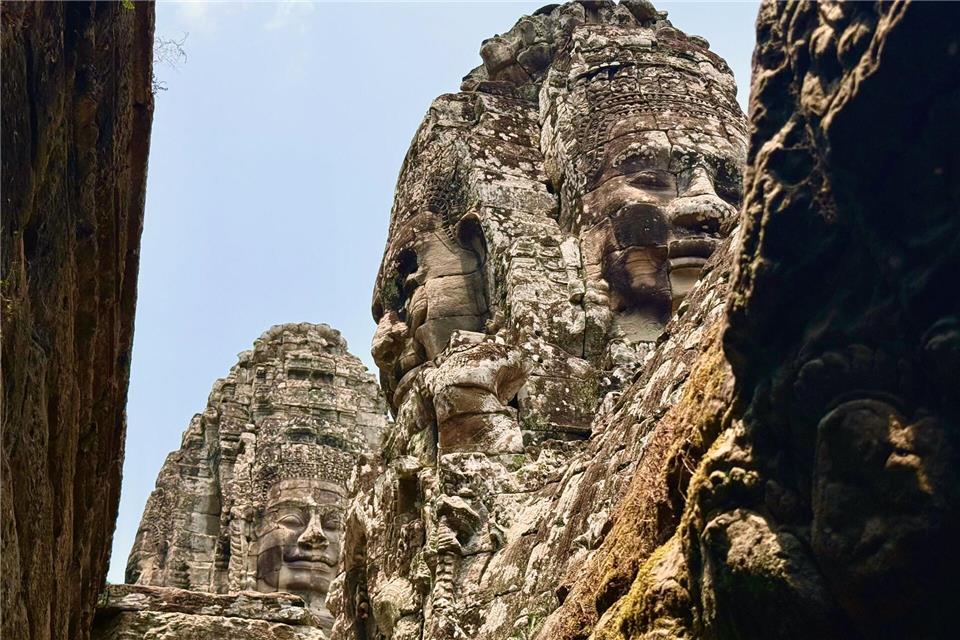 Steinerne Gesichter des Bayon-Tempels in der antiken Stadt Angkor Thom - kaum jemand lächelt zurück dieser Tage.Carola Frentzen/dpa-tmn