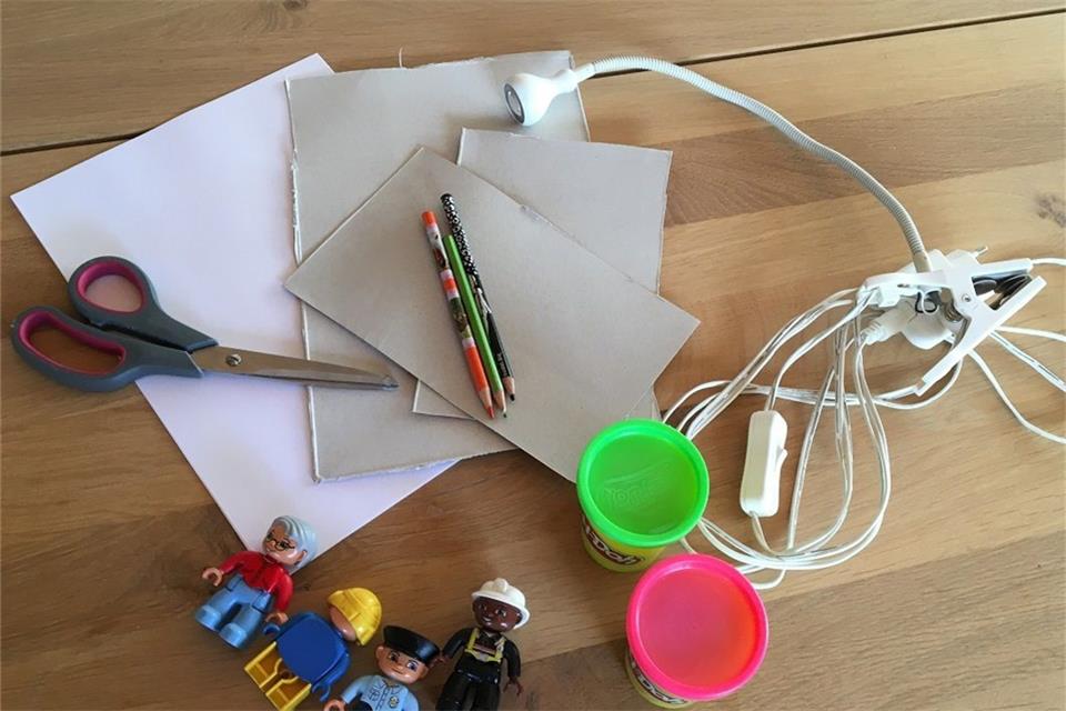 Stift, eine Schere, Papier, Lichtquellen und einige Figuren: Viel mehr braucht man nicht für das heutige Experiment. 