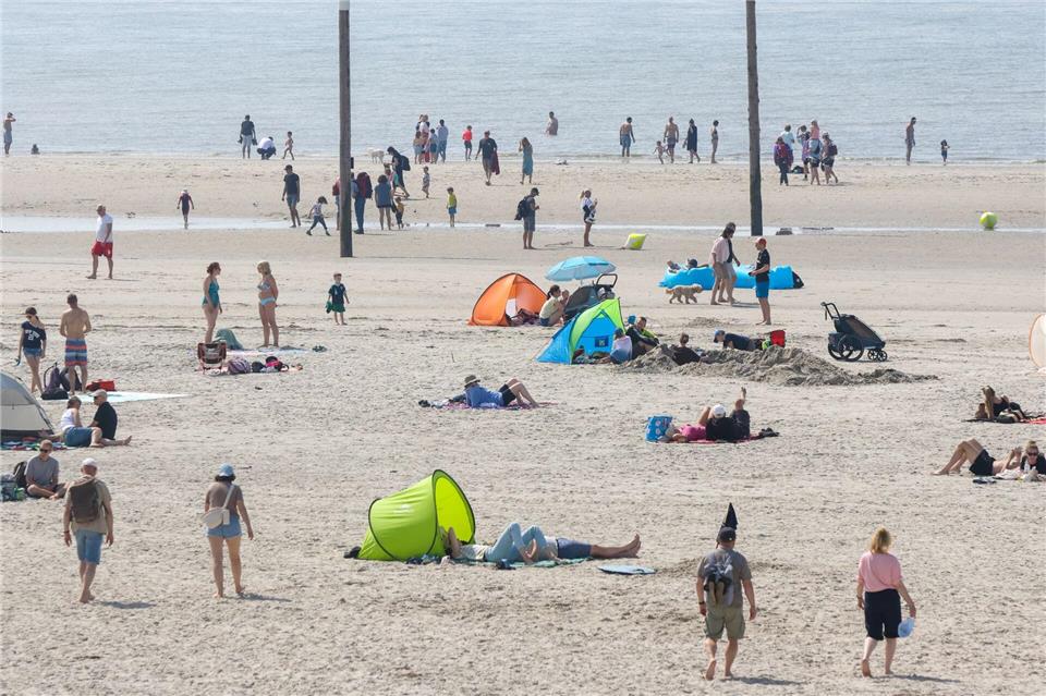 Strandbesucher liegen an der Nordsee. (Archivbild) Bodo Marks/dpa