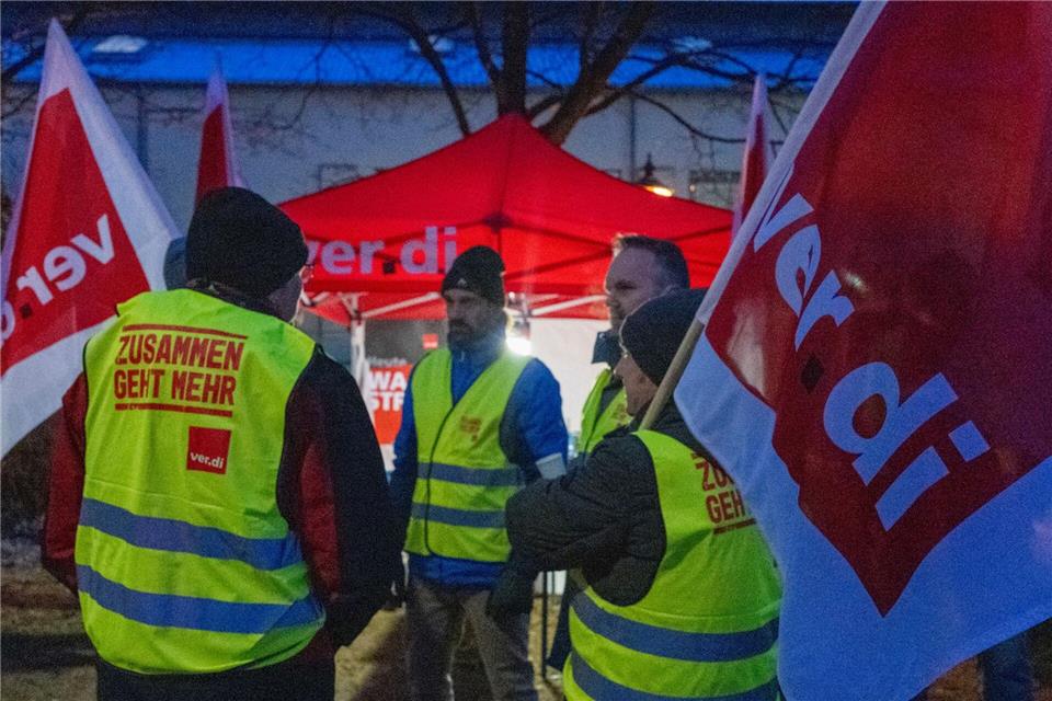 Streikende halten Fahnen der Gewerkschaft Verdi und sind mit Warnwesten gekleidet. Stefan Puchner/dpa