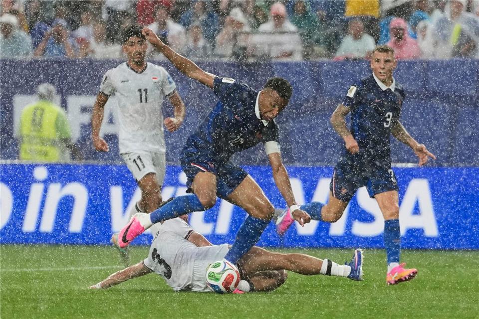 Stürmerstar im Regen: Frankreichs Kylian Mbappé im Zweikampf mit dem Iraker Hussein Ali.Matt Slocum/AP/dpa