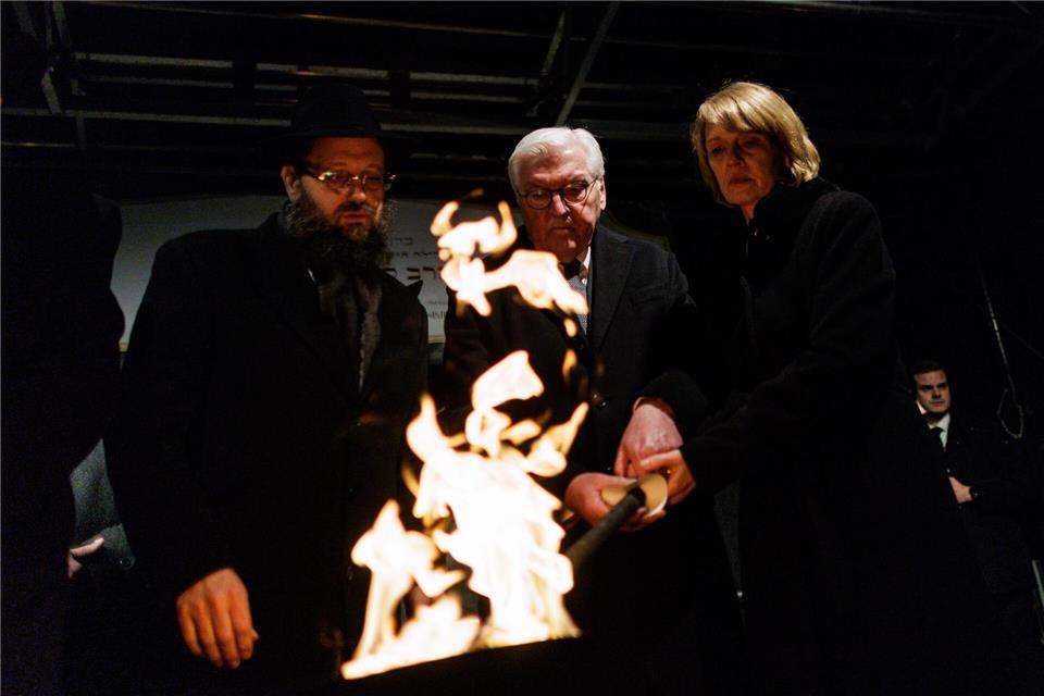 Stunden nach dem brutalen Anschlag in Sydney zündeten Rabbiner Yehuda Teichtal (l), Bundespräsident Frank-Walter Steinmeier und seine Frau Elke Büdenbender gemeinsam eine Fackel für die erste Kerze des Chanukka-Leuchters vor dem Brandenburg Tor an. Carsten Koall/dpa