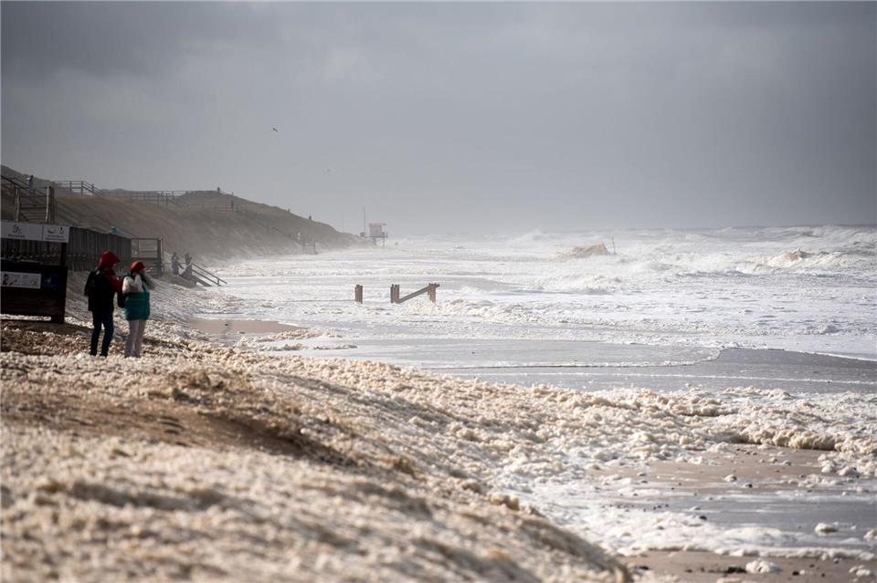 Sturmflut vor Sylt. Das Wetter lockte auch Spaziergänger an die Nordsee.Daniel Bockwoldt/dpa