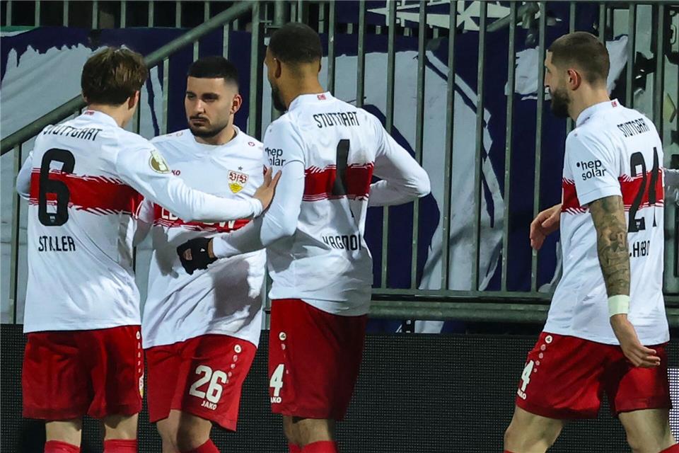 Stuttgarts Deniz Undav (M) feiert mit den Teamkollegen Angelo Stiller (l) und Josha Vagnoman nach seinem Tor zum 1:0 in Kiel.Christian Charisius/dpa