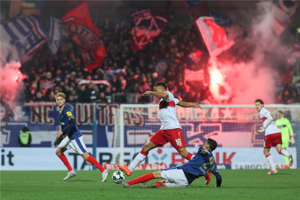 Stuttgarts Jamie Leweling und Kiels Jonas Meffert kämpfen um den Ball.Christian Charisius/dpa