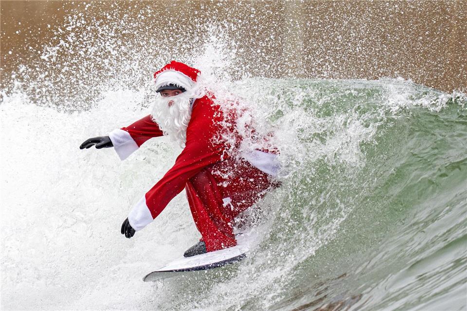 Surflehrer und Rettungsschwimmer Finn Clark aus Gorebridge verkleidet sich als Weihnachtsmann für eine Surfsession im Lost Shore Surf Resort in Newbridge, in der Nähe von Edinburgh.Jane Barlow/PA Wire/dpa