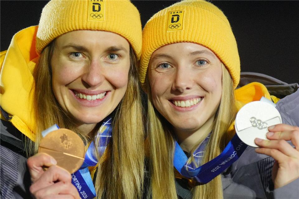 Susanne Kreher und Jacqueline Pfeifer zeigen bei der Siegerehrung ihre Medaillen bei den Olympischen Winterspielen Mailand Cortina 2026.Michael Kappeler/dpa