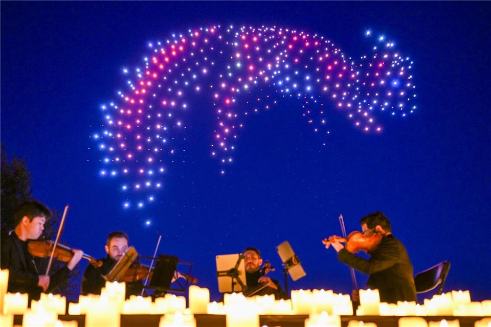 Sychronisierte Drohnen formen bei einer DroneArt Show Lichtbilder am Himmel über den Gärten der Welt in Berlin.Jens Kalaene/dpa