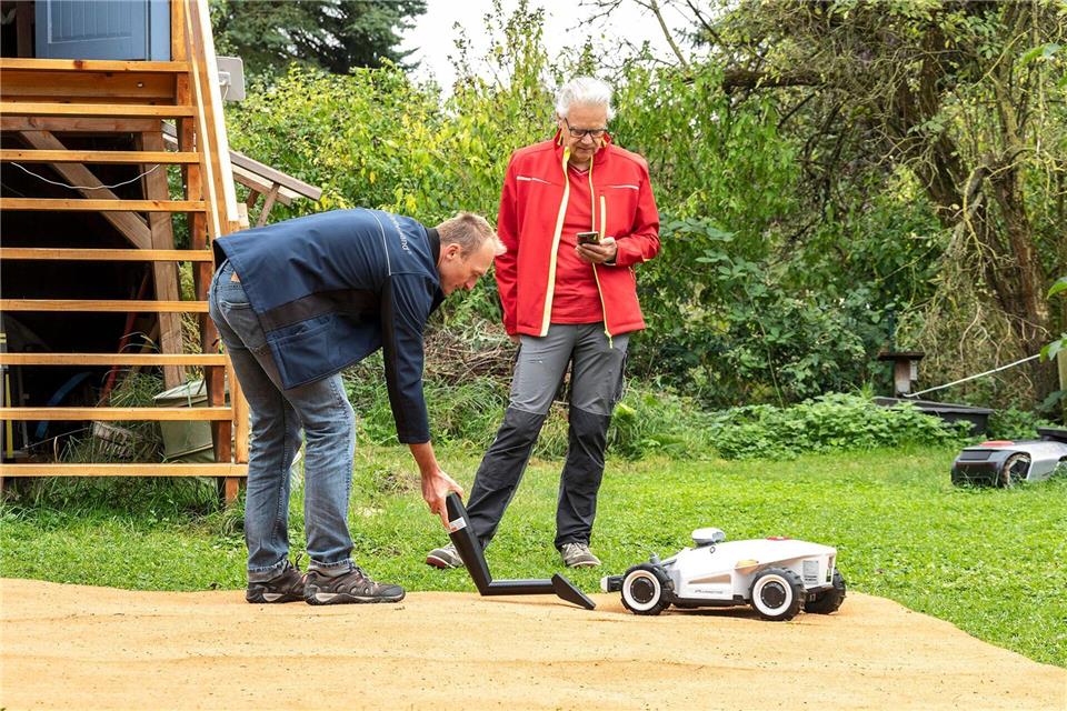 TÜV-Experte Alexander Baumstark (l) und Peter Carla Baruschke von der Zeitschrift „Selbst ist der Mann“ beim Sicherheits-Check der Mähroboter.Michael Müller-Münker/selbst ist der Mann/dpa-tmn