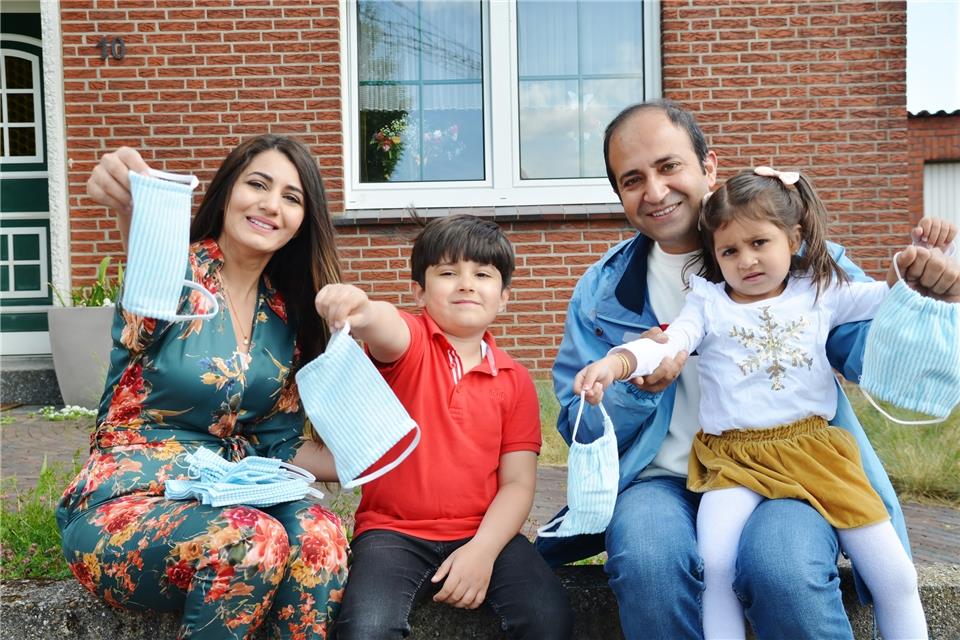 Talat und Zainab Mamou präsentieren mit ihren Kindern die handgefertigten Masken.