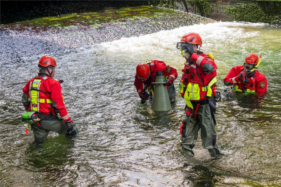 Taucher suchen nach dem Ablassen des Wassers am Bachgrund nach einer Unfallursache. (Archivfoto)  Peter Kneffel/dpa