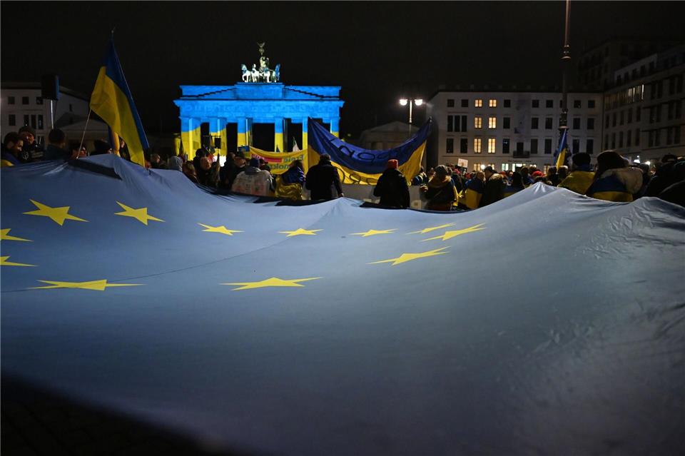 Tausende von Demonstranten versammelten sich vor dem in den Nationalfarben der Ukraine angestrahlten Brandenburger Tor. Markus Lenhardt/dpa