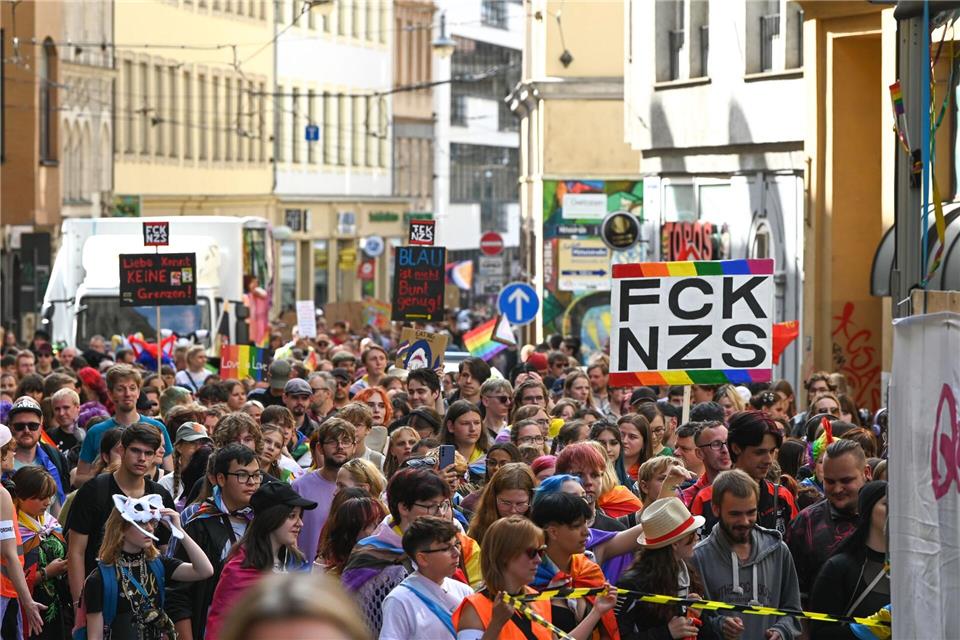 Teilnehmende des CSD ziehen mit Regenbogenfahnen und Plakaten durch die Innenstadt von Halle.Heiko Rebsch/dpa