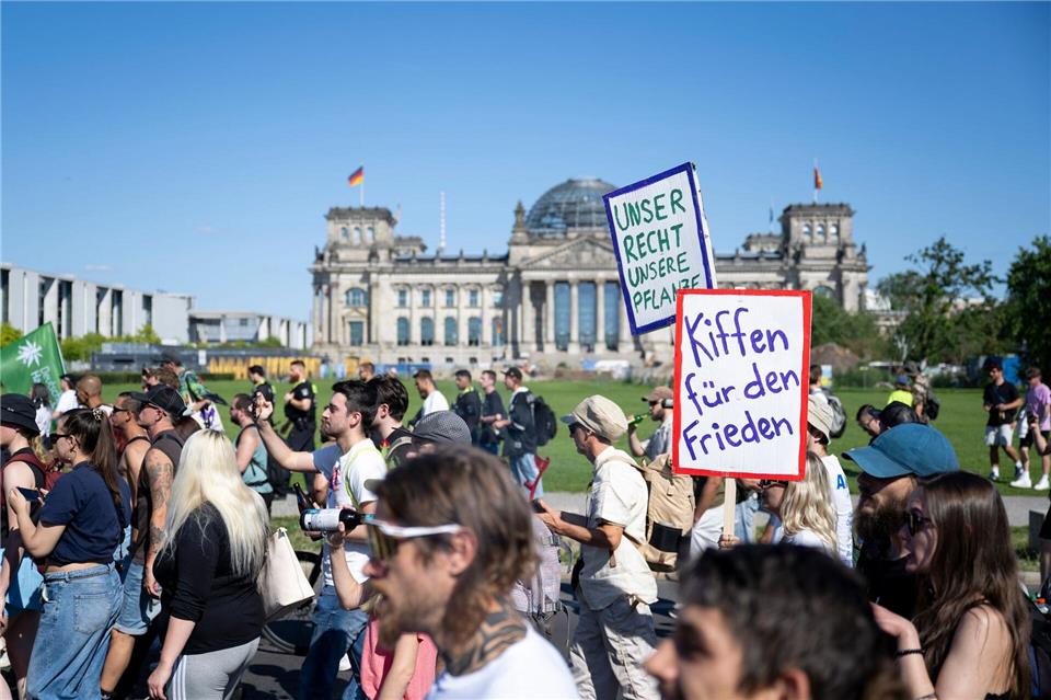 Teilnehmer der Hanfparade 2026 unter dem Motto „Gerecht! Gesund! Genießen!“ tragen Transparente und Plakate vor dem Reichstagsgebäude.Christophe Gateau/dpa
