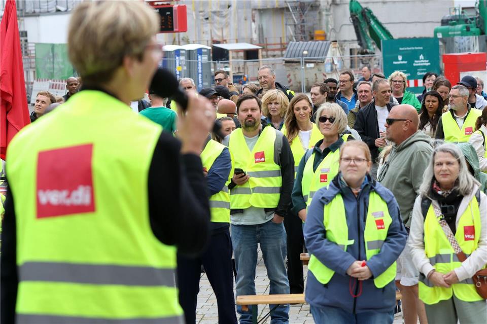 Teilnehmer der Kundgebung hören einer Rednerin zu. Bodo Marks/dpa
