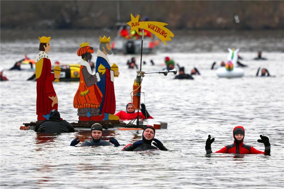 Teilnehmer des 40. Drei-König-Schwimmens treiben im Wasser des Mains.Karl-Josef Hildenbrand/dpa