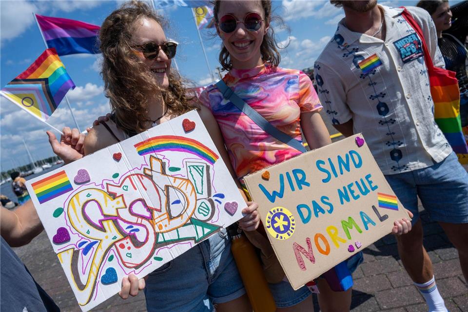 Teilnehmer des CSD in Rostock zeigen ihre Botschaften.Stefan Sauer/dpa