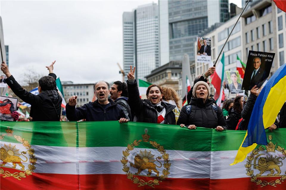 Teilnehmer halten Flaggen der iranischen Monarchie bei einer Demonstration in Frankfurt in die Höhe.Hannes P Albert/dpa