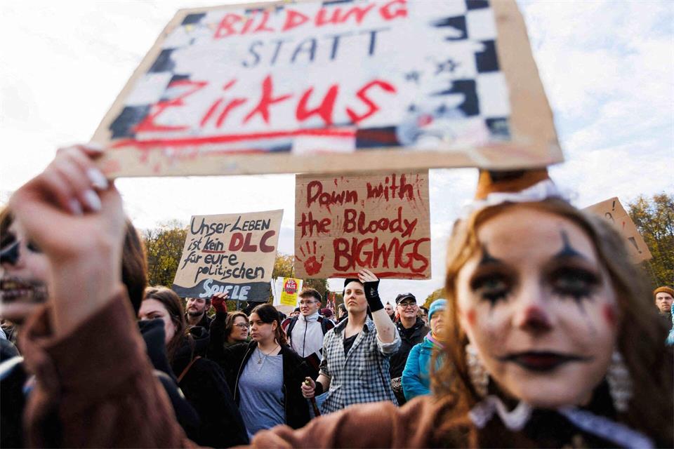 Teilnehmer halten Schilder hoch mit verschiedenen Protestparolen während der Kundgebung unter dem Motto „Gen Z regelt“Carsten Koall/dpa