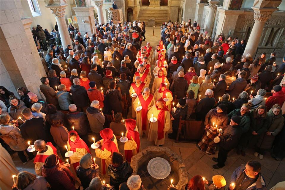 Teilnehmer verteilen das Osterlicht in der Stiftskirche St. Cyriakus. (Archivbild)Matthias Bein/dpa