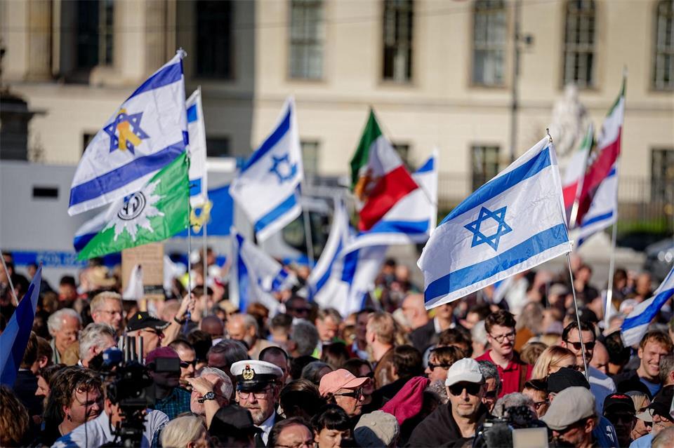 Teilnehmer zeigen die Fahne Israels bei einer Gedenkveranstaltung zum Jahrestag des Terrorangriffs auf dem Bebelplatz.Kay Nietfeld/dpa