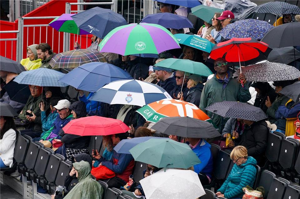 Tennis im Regen: Bei der WTA-Tour in London schützen sich Zuschauer mit Schirmen gegen einen Schauer. Alberto Pezzali/AP/dpa