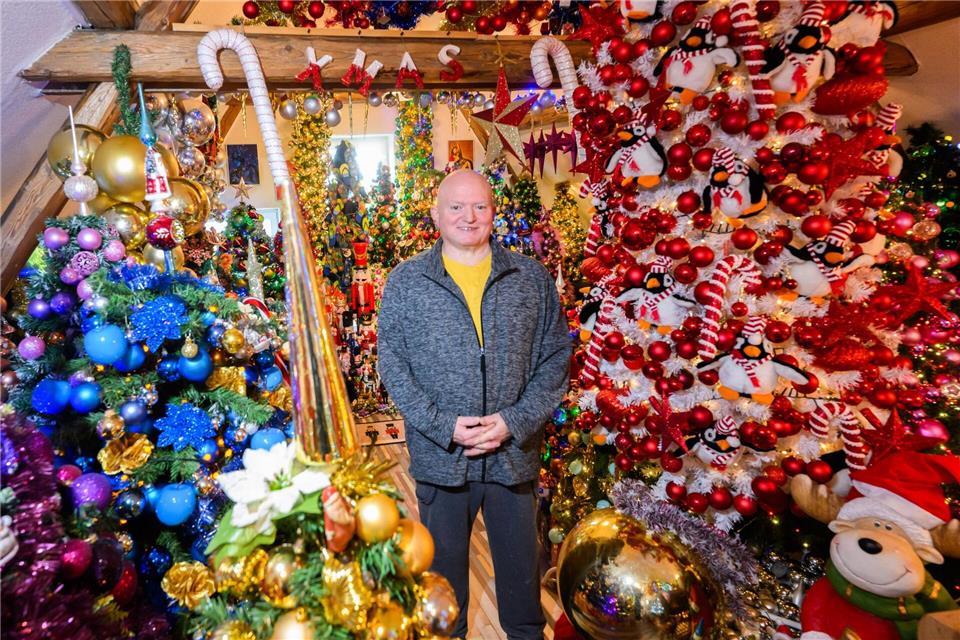 Thomas Jeromin steht inmitten von Weihnachtsbäumen in seinem Haus im Landkreis Schaumburg. Julian Stratenschulte/dpa