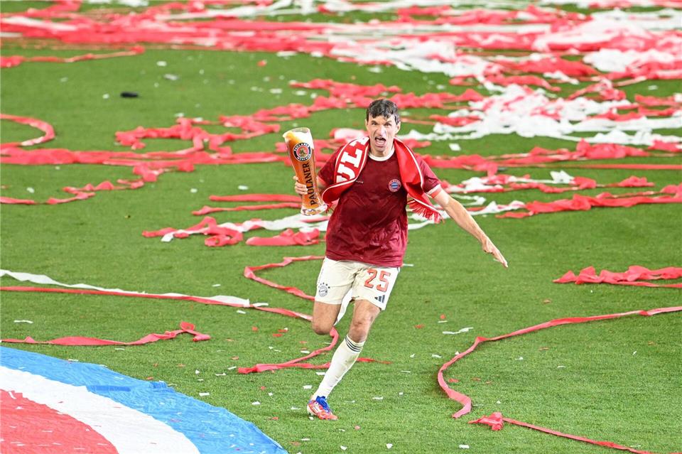 Thomas Müller rennt bei der Meisterfeier mit Bier über das Feld.Sven Hoppe/dpa
