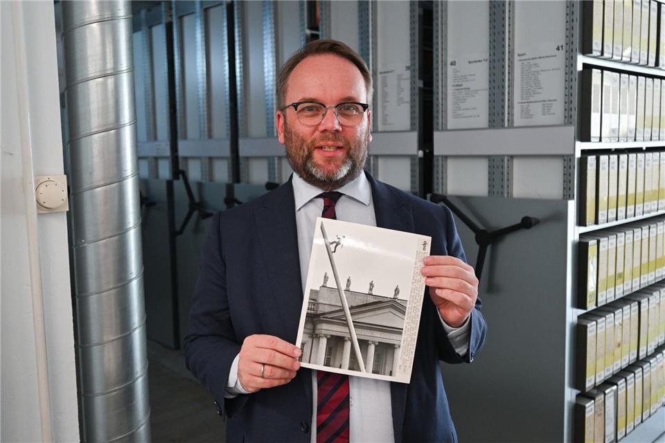 Timon Gremmels (SPD), Hessens Minister für Kunst und Kultur, hält ein Foto einer früheren documenta in Kassel in den Händen. (Archivbild)Arne Dedert/dpa