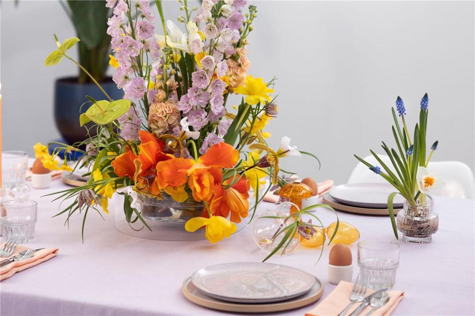 Inspiration für Ostern: Mit Blüten den Frühling begrüßen Tischdekoration für Ostern: Farbenfrohe Blumen in verschiedenen Höhen in einer flachen Schale arrangiert.Tollwasblumenmachen.de/dpa-tmn