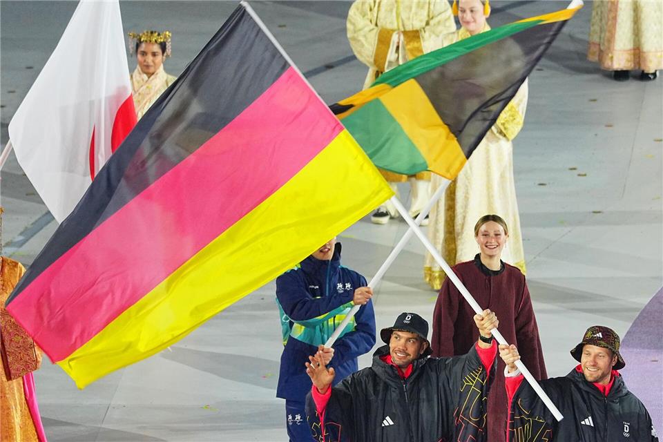 Tobias Wendl (l) und Tobias Arlt tragen die deutsche Fahne. Michael Kappeler/dpa